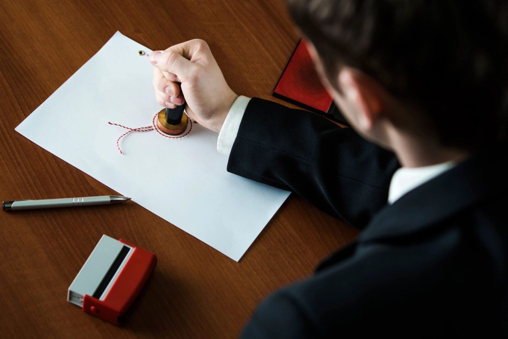 A man in a suit is signing a document.