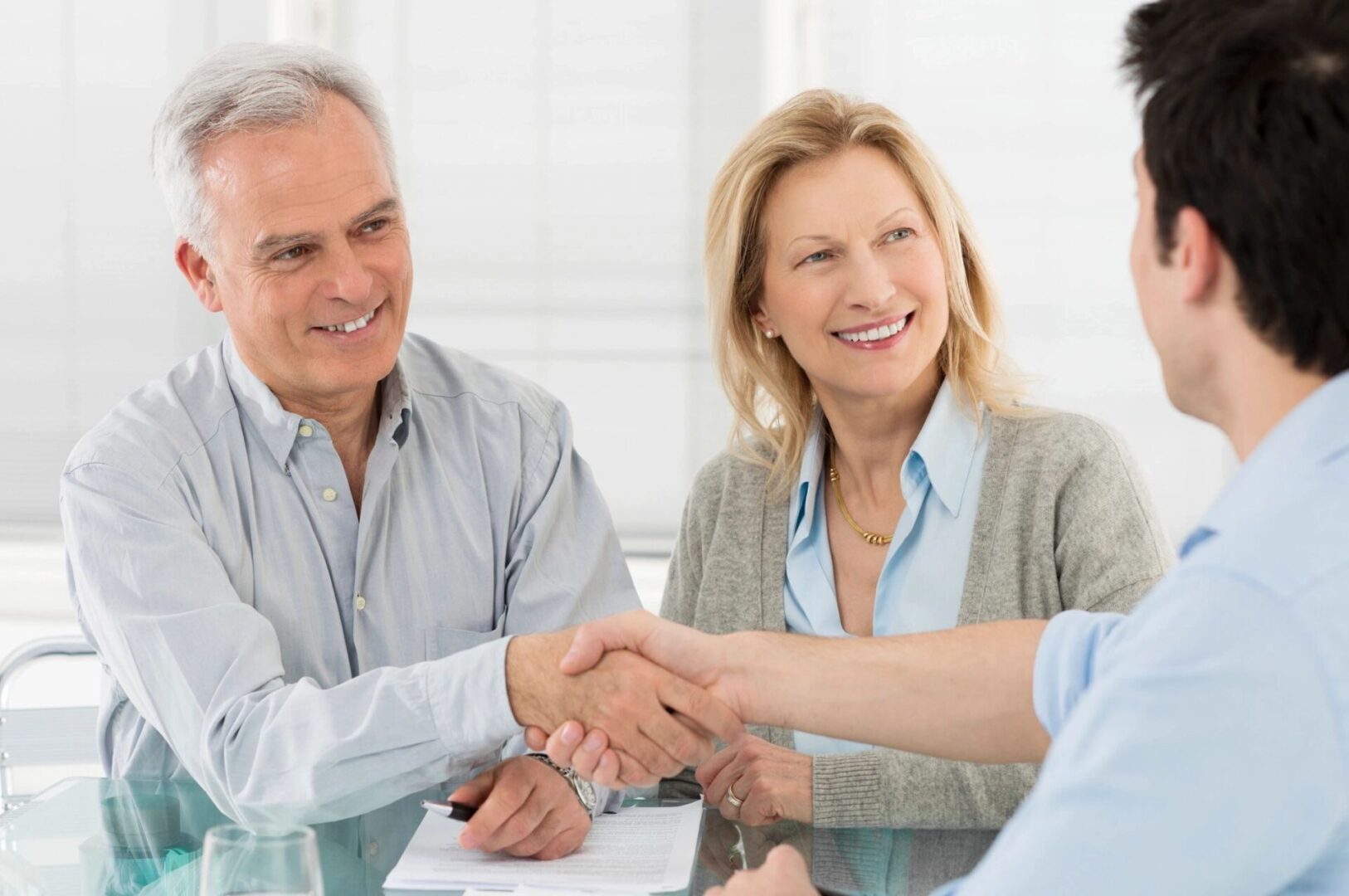 A man and woman shaking hands at a meeting.