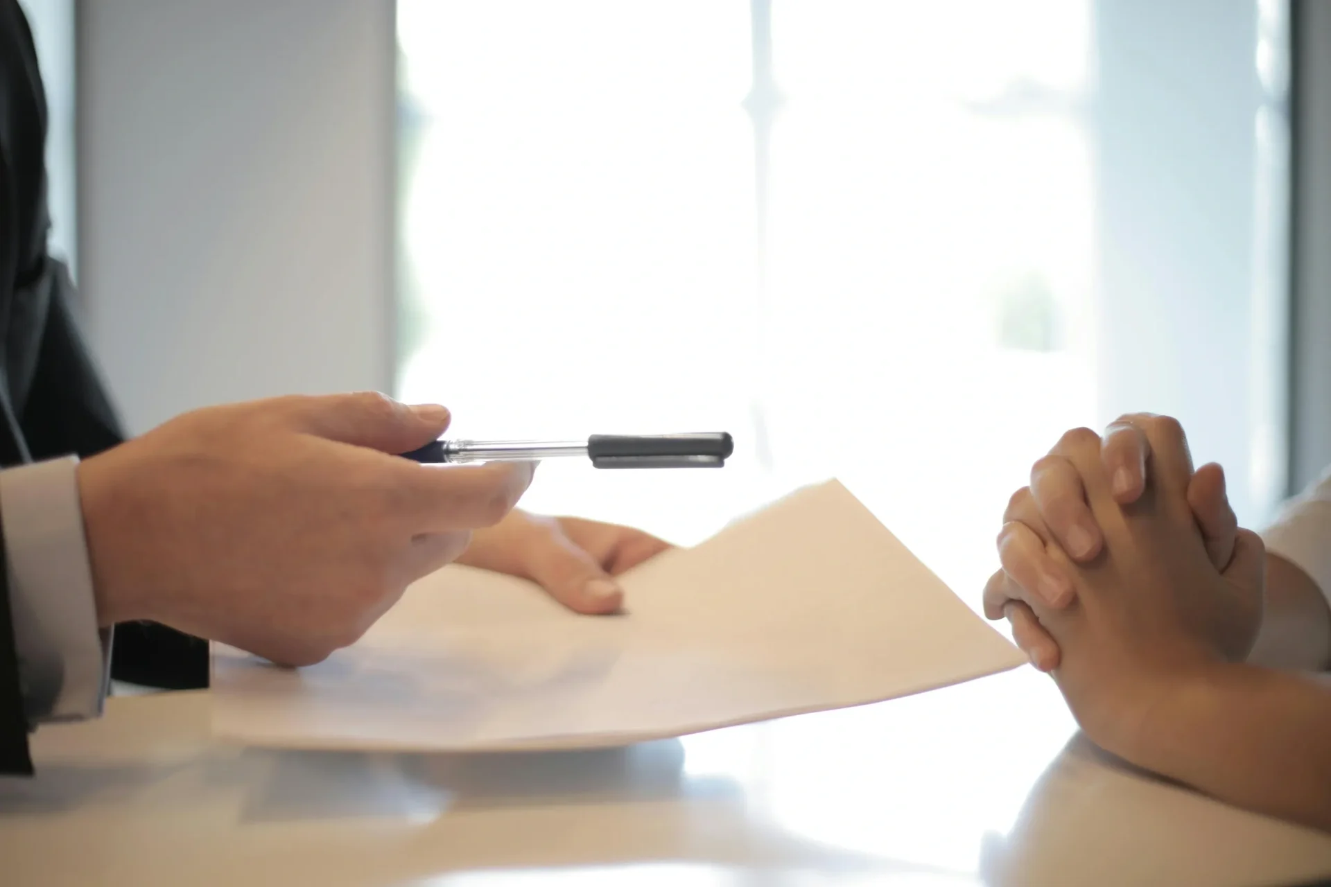 A man and woman are holding a piece of paper and a pen.