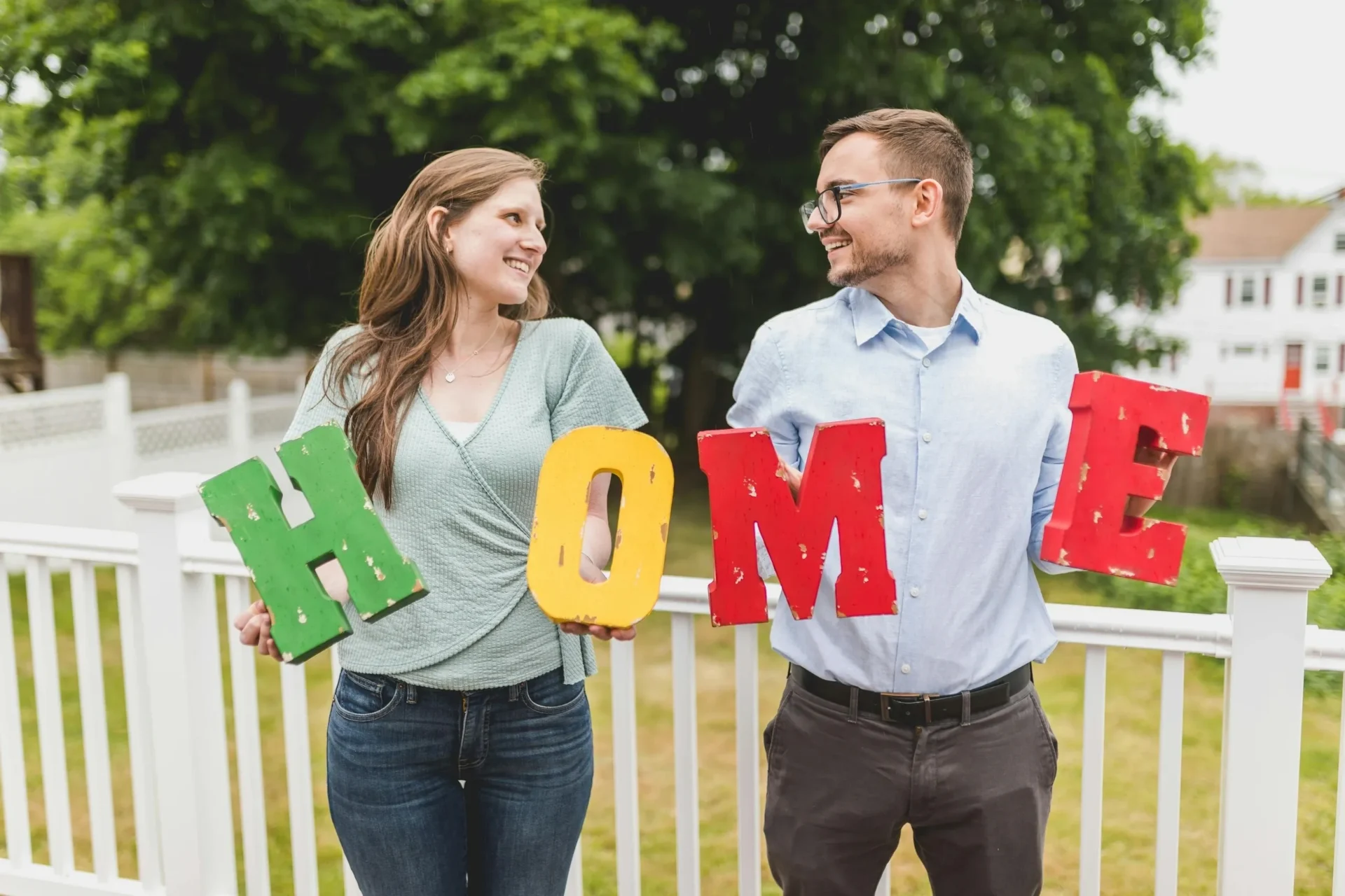 A couple holding up signs that say home.